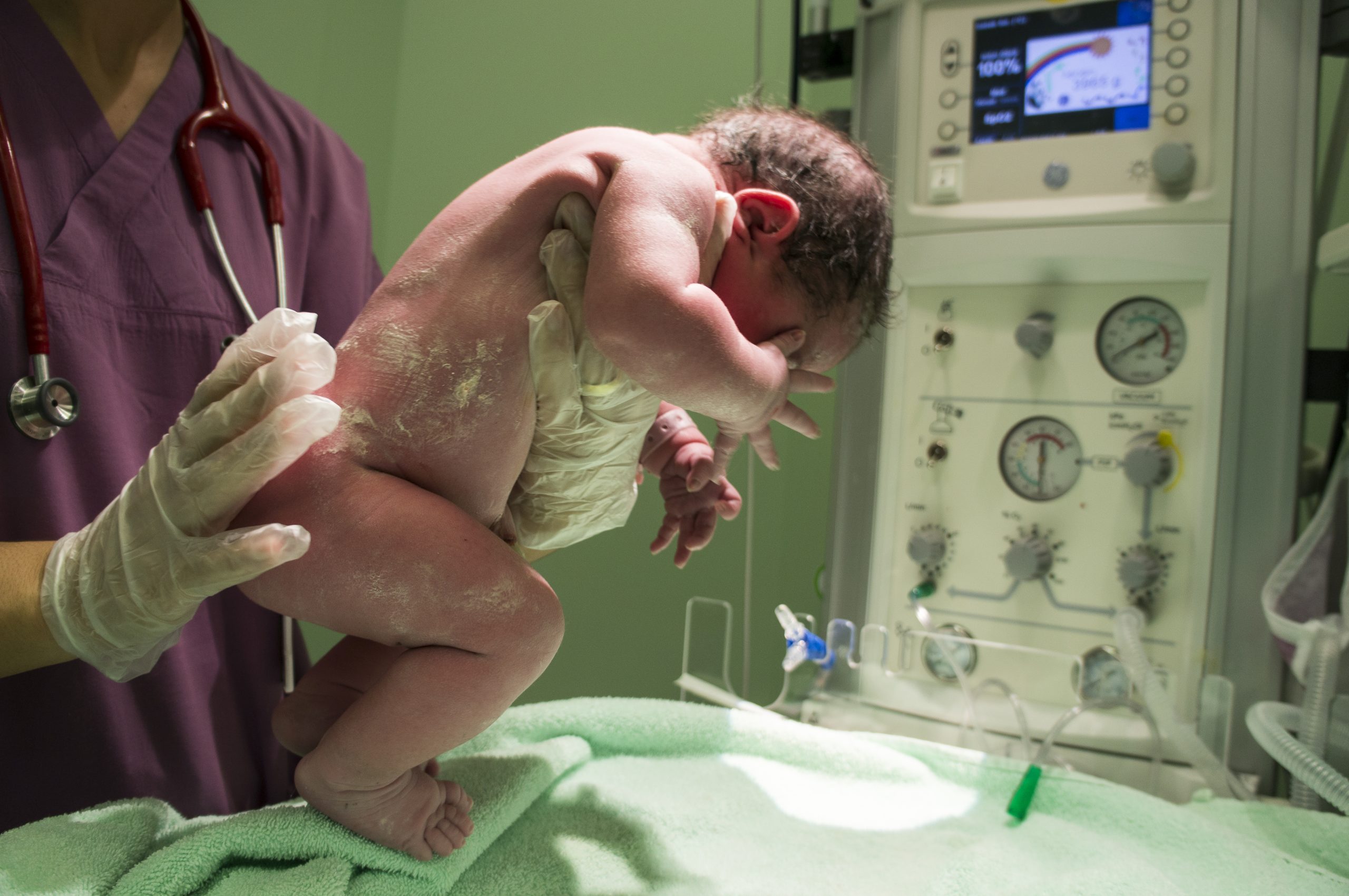 recém-nascido nas mãos de profissional médico